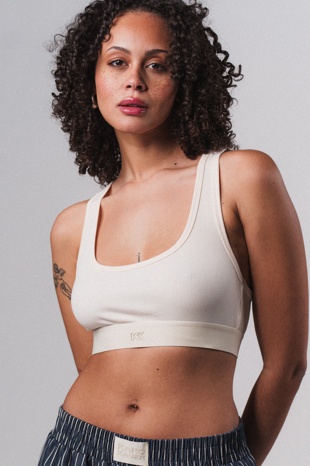 Frau im cremefarbenen Bralette Off White mit KK Print aus Out of the Blue Collection