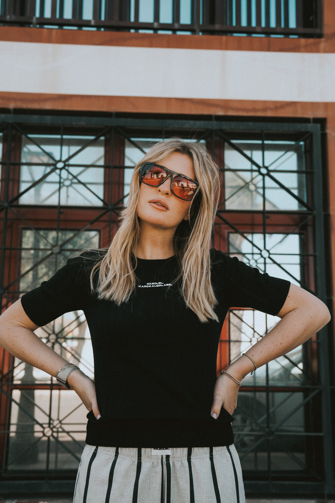 Frau im schwarzen Knit T-Shirt mit KK20LBL Print, Frontalansicht aus UNFILTERED