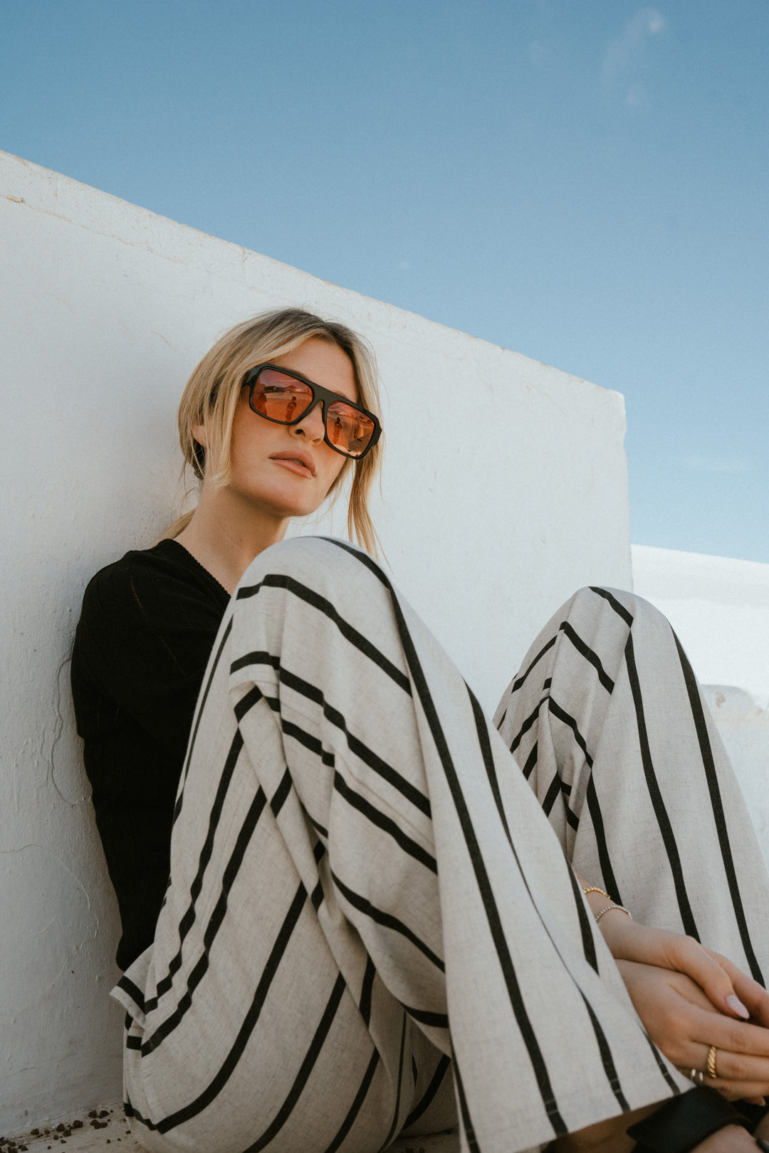 Frau in beige-schwarz gestreiften Woven Pants, sitzende Pose aus UNFILTERED