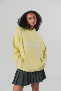 Frontalansicht einer Frau im gelben Hoodie aus The Escape Collection