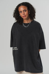 Oberkörperaufnahme: Frontalansicht einer Frau im schwarzen Oversized T-Shirt aus der Escape Collection