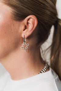 Detailaufnahme: Silberne Oval Hoops am Ohr einer Frau aus The Escape Collection