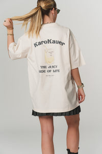 Rückenansicht einer Frau im beigen Oversized T-Shirt mit KaroKauer Print aus der Escape Collection"