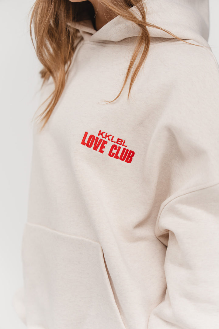 Hoodie Love Club, Halbkörper schräg vorne, beiger Hoodie, Love Club Rubber Print, überschnittene Schultern