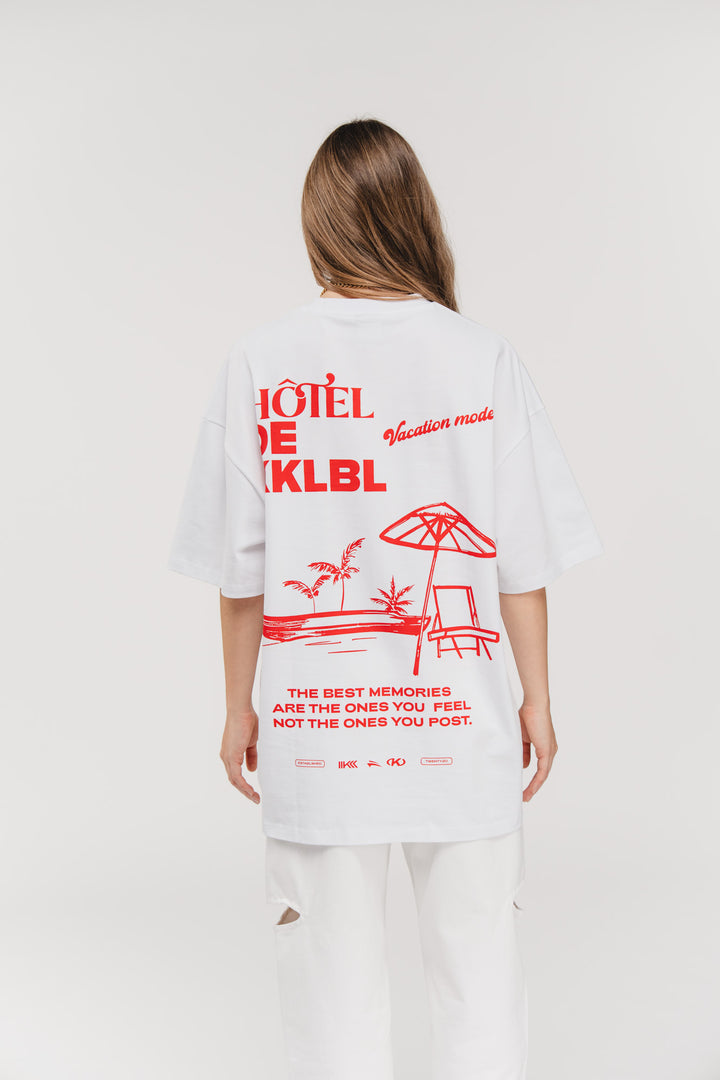 T-Shirt Vacation, Ganzkörper Rückenansicht, weißes Oversized-Shirt, großer Hotel de KKLBL Statement-Print