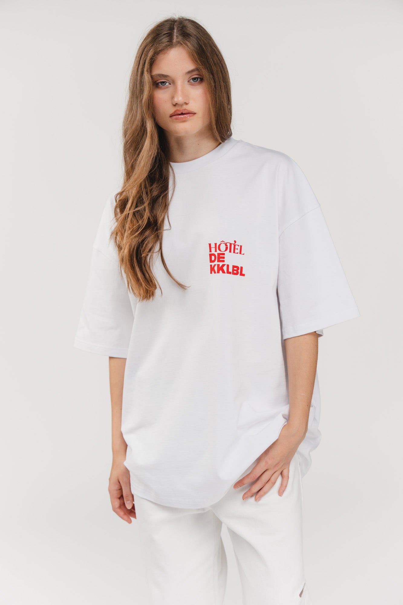 T-Shirt Vacation, Halbkörper frontal, weißes Oversized-Shirt, kleiner Hotel de KKLBL Print vorne in Rot