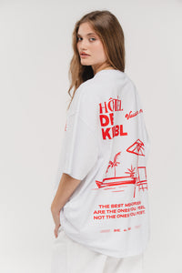 T-Shirt Vacation, Halbkörper schräg hinten, weißes Oversized-Shirt, großer Hotel de KKLBL Print in Rot