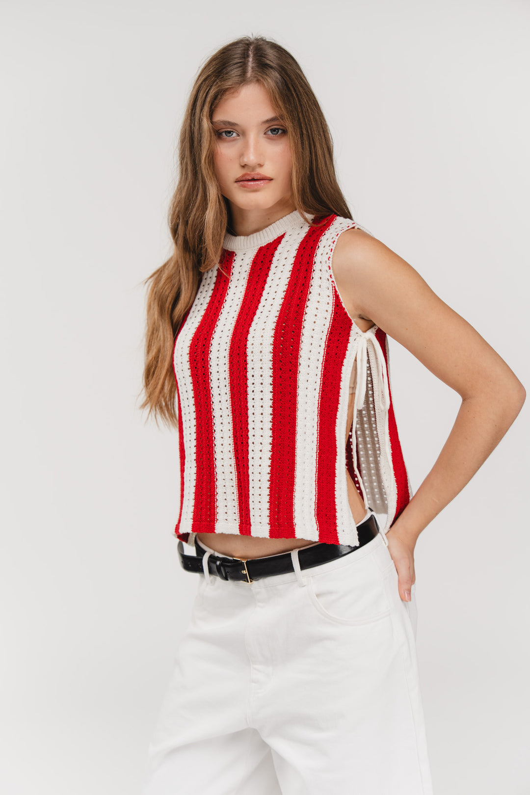 Knit Vest Striped Red, Halbkörper frontal, rot-weißes Stricktop, offene Seiten mit Binde-Bändern, Hand in Hüfte