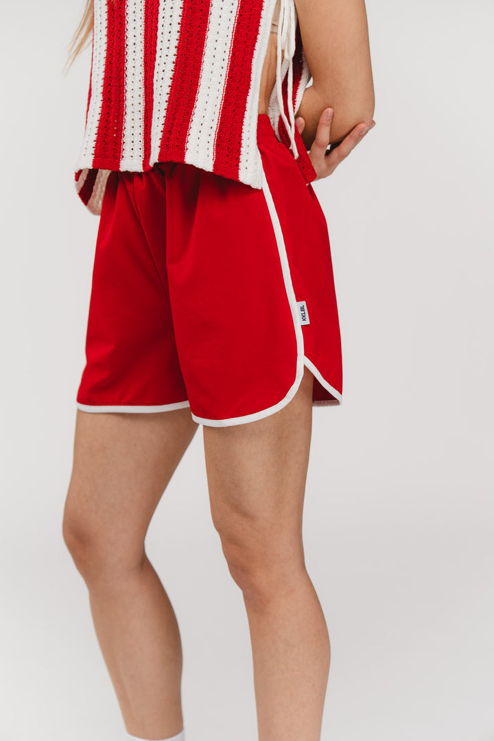Track Shorts Red, Detailaufnahme, rote Retro-Shorts mit weißem Kontrastrand und elastischem Bund