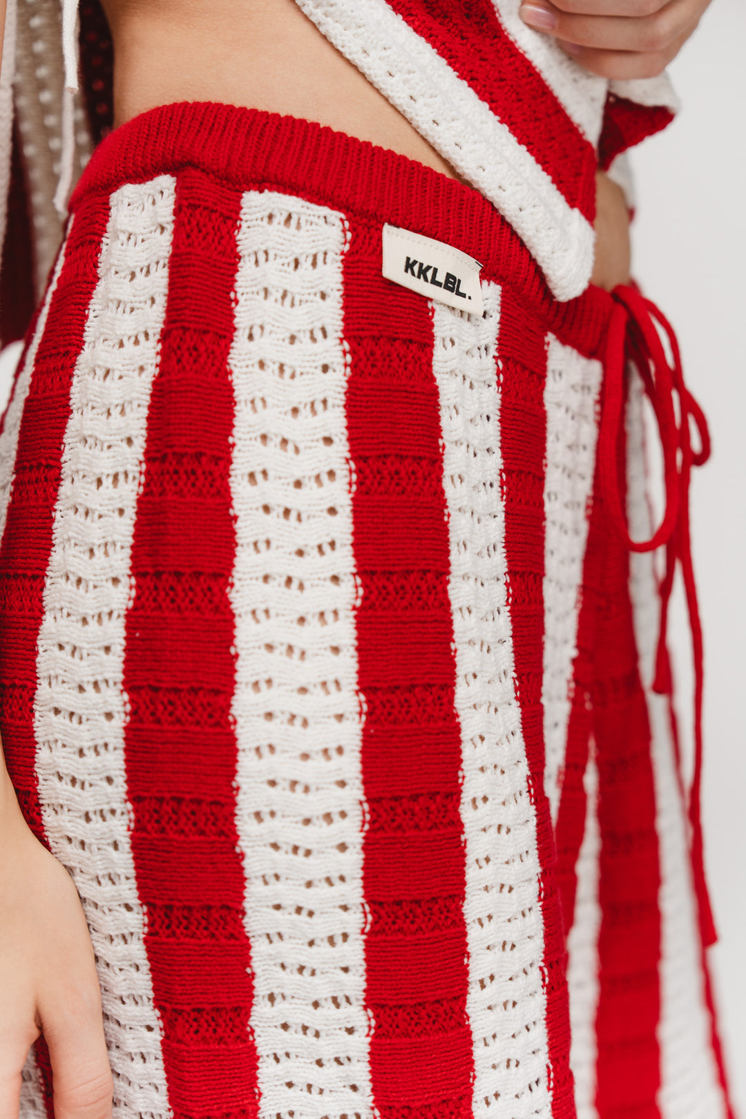 Knit Pants Striped Red, Detailaufnahme Bindeband am Bund, Strickware mit Streifenmuster in Rot-Weiß