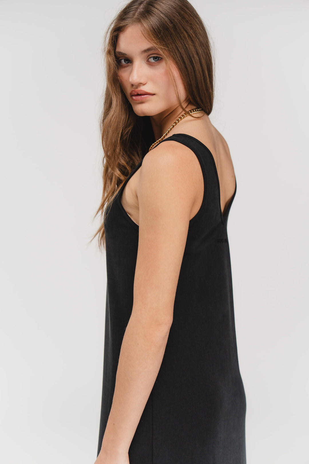 Loose Dress Black, Halbkörper seitlich, langes schwarzes Kleid, tiefer Ausschnitt, schlichtes Design