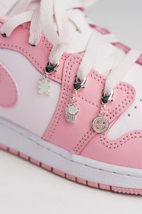 Charm Set Silver, Detailaufnahme drei silberne Charms an rosa Sneaker, Smiley, Pommes-Frites und KKLBL-Logo