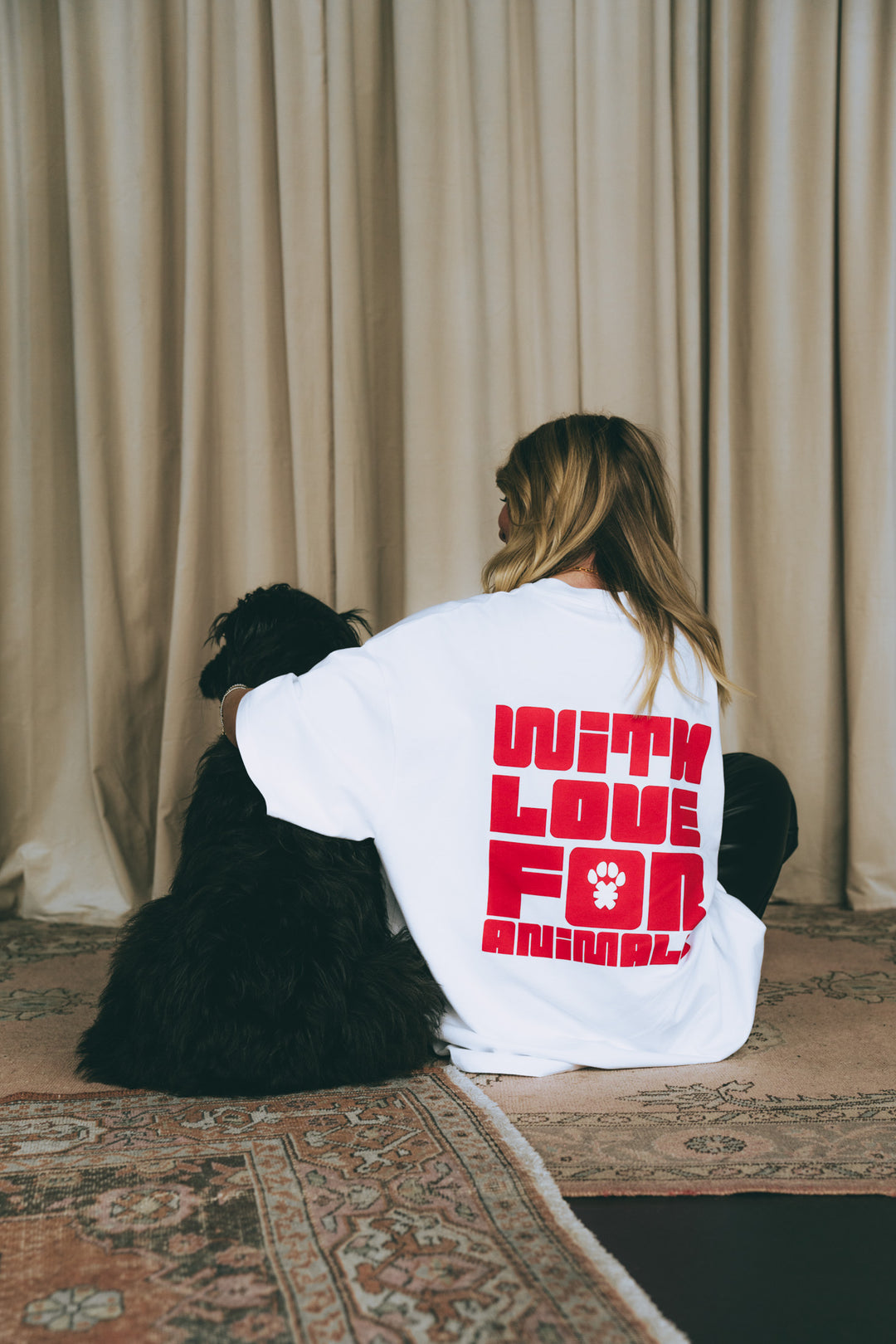 Hund und Frau im weißen T-Shirt mit rotem 'WITH LOVE FOR ANIMALS' Print, Rückansicht