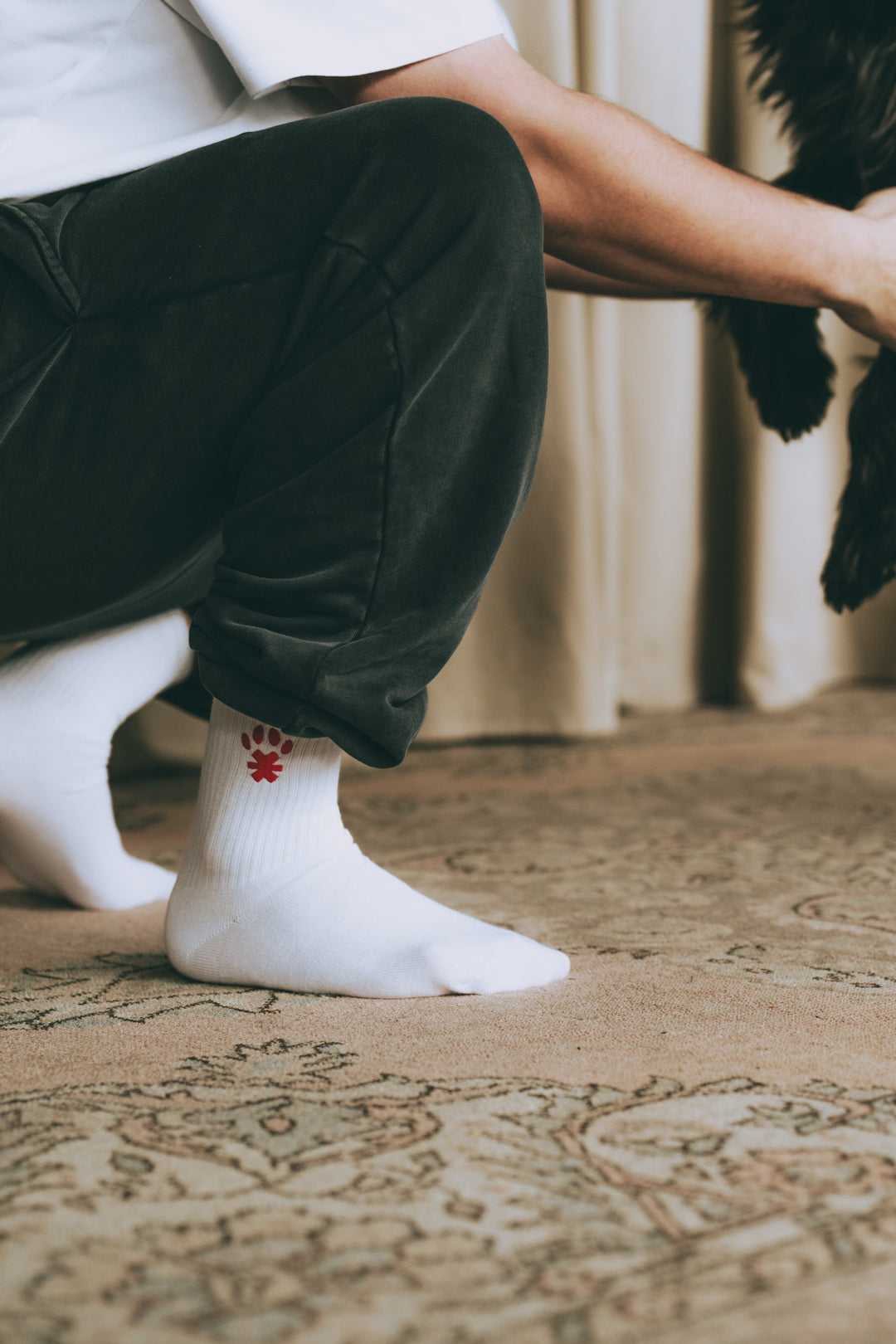 Detailaufnahme: Frau mit weißen Socken mit rotem Pfotenprint