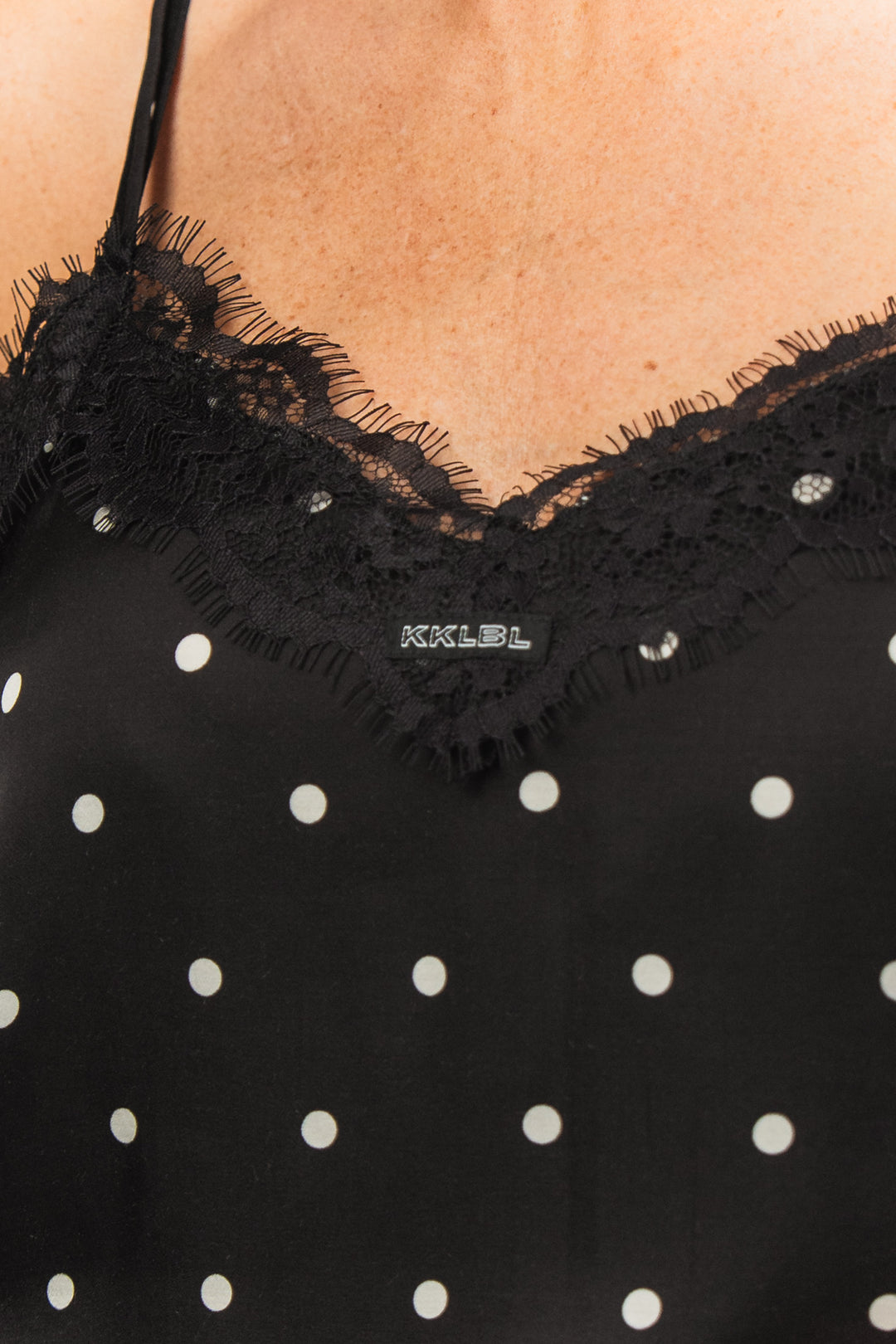 Satin Lace Top Dots Black, Detailaufnahme V-Ausschnitt mit Spitzenbesatz, schwarzes Satin mit weißen Punkten