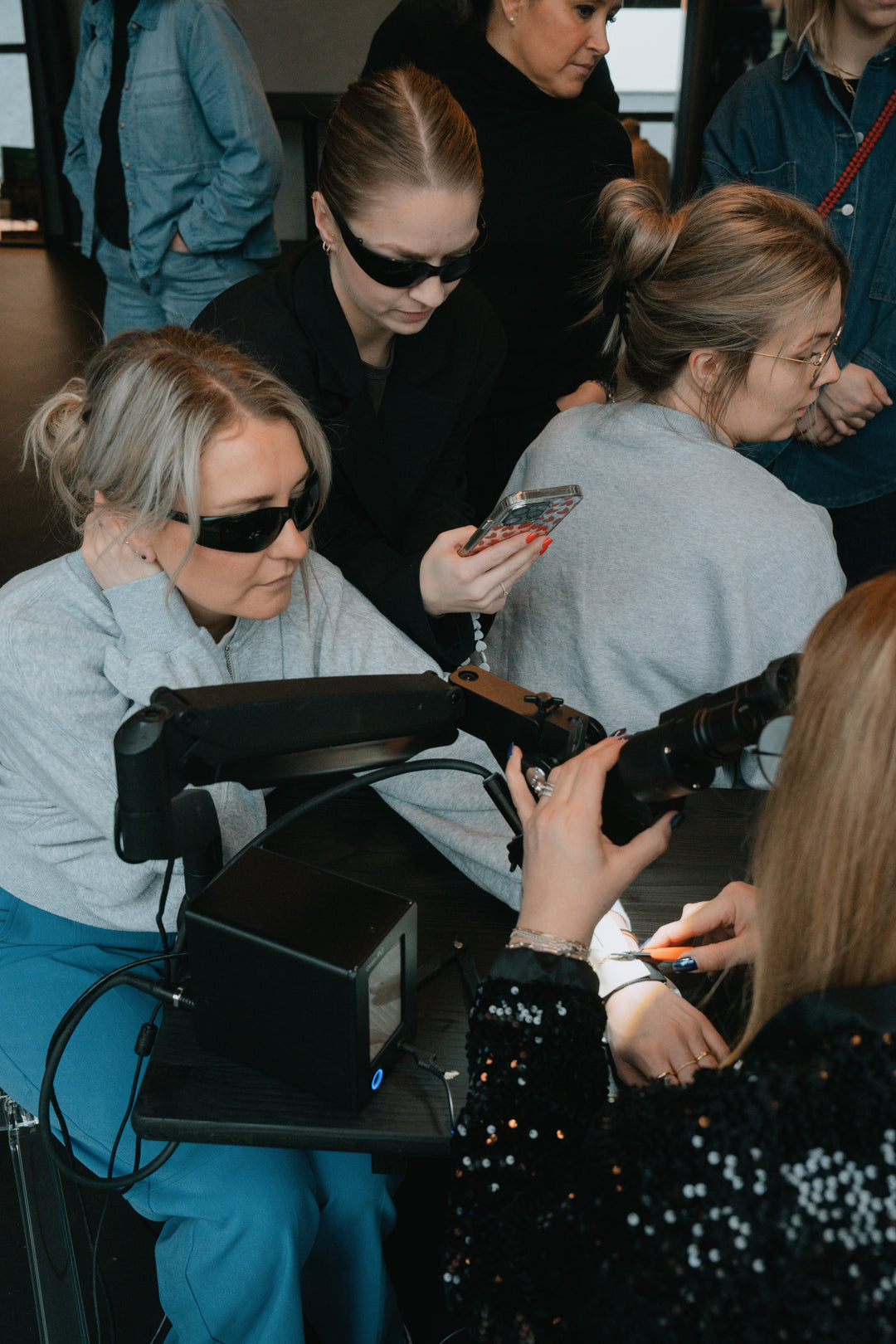 Gruppenaufnahme: Frauen in grauen Hoodies bei Workshop-Aktivität, sitzende Pose