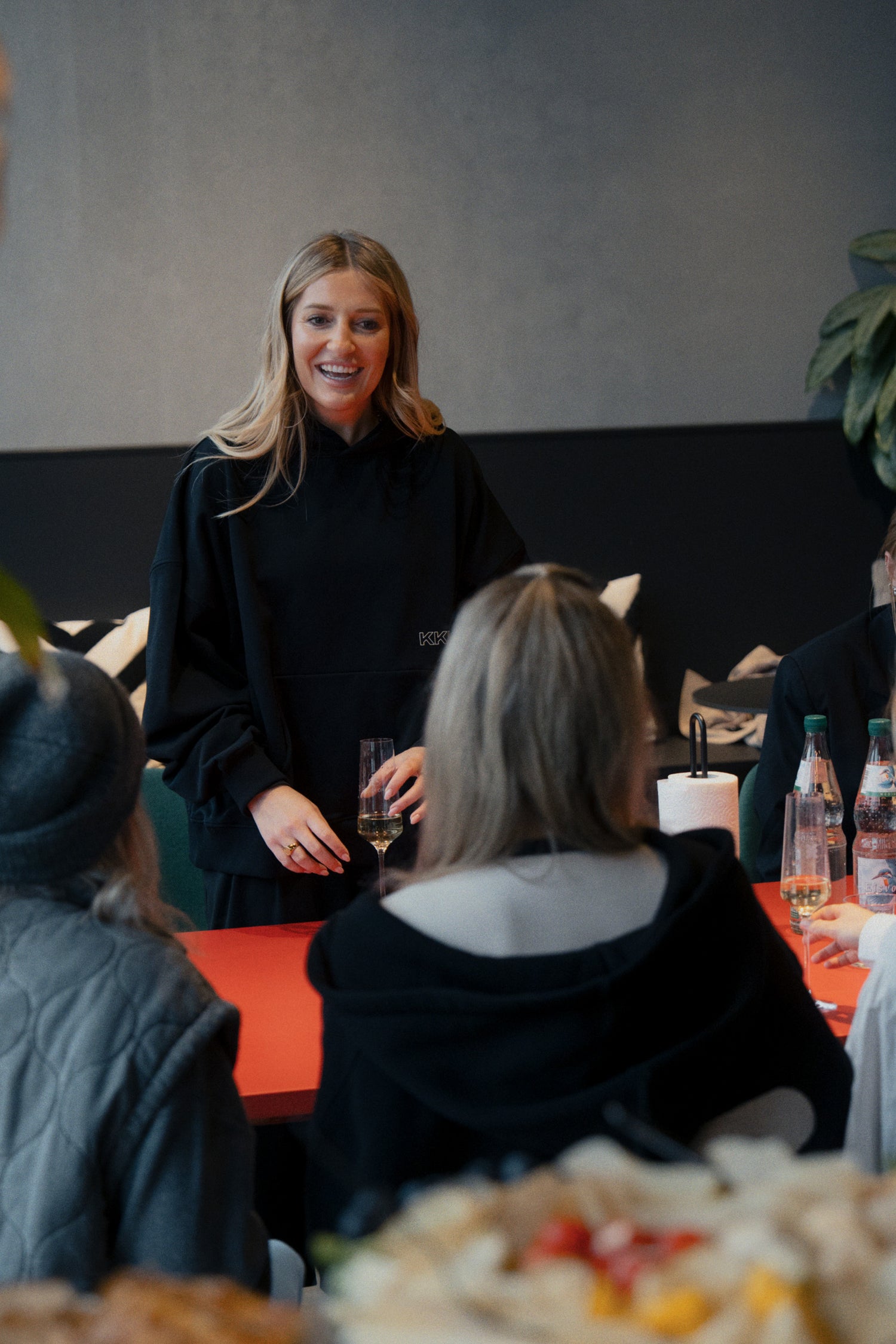 Frau im schwarzen Oversized Pullover bei Event, stehende Pose