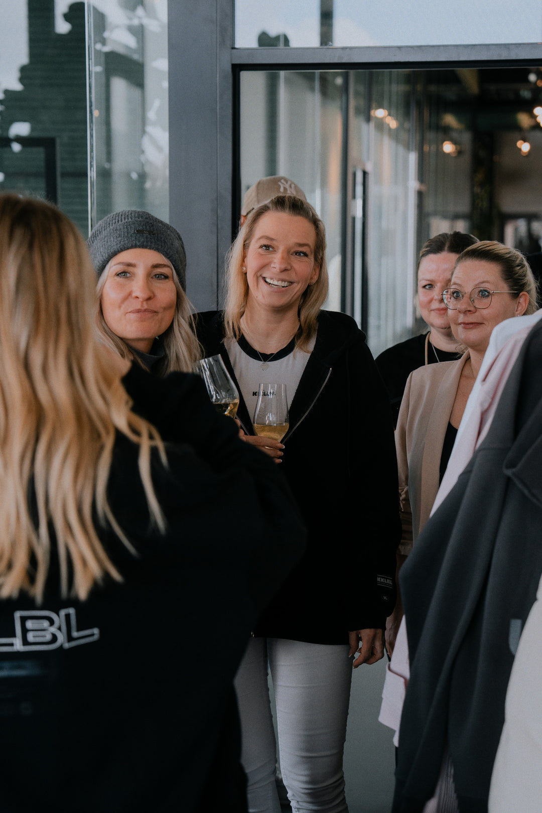 Gruppenaufnahme: Frauen in schwarzen Oberteilen vor KKLBL Store