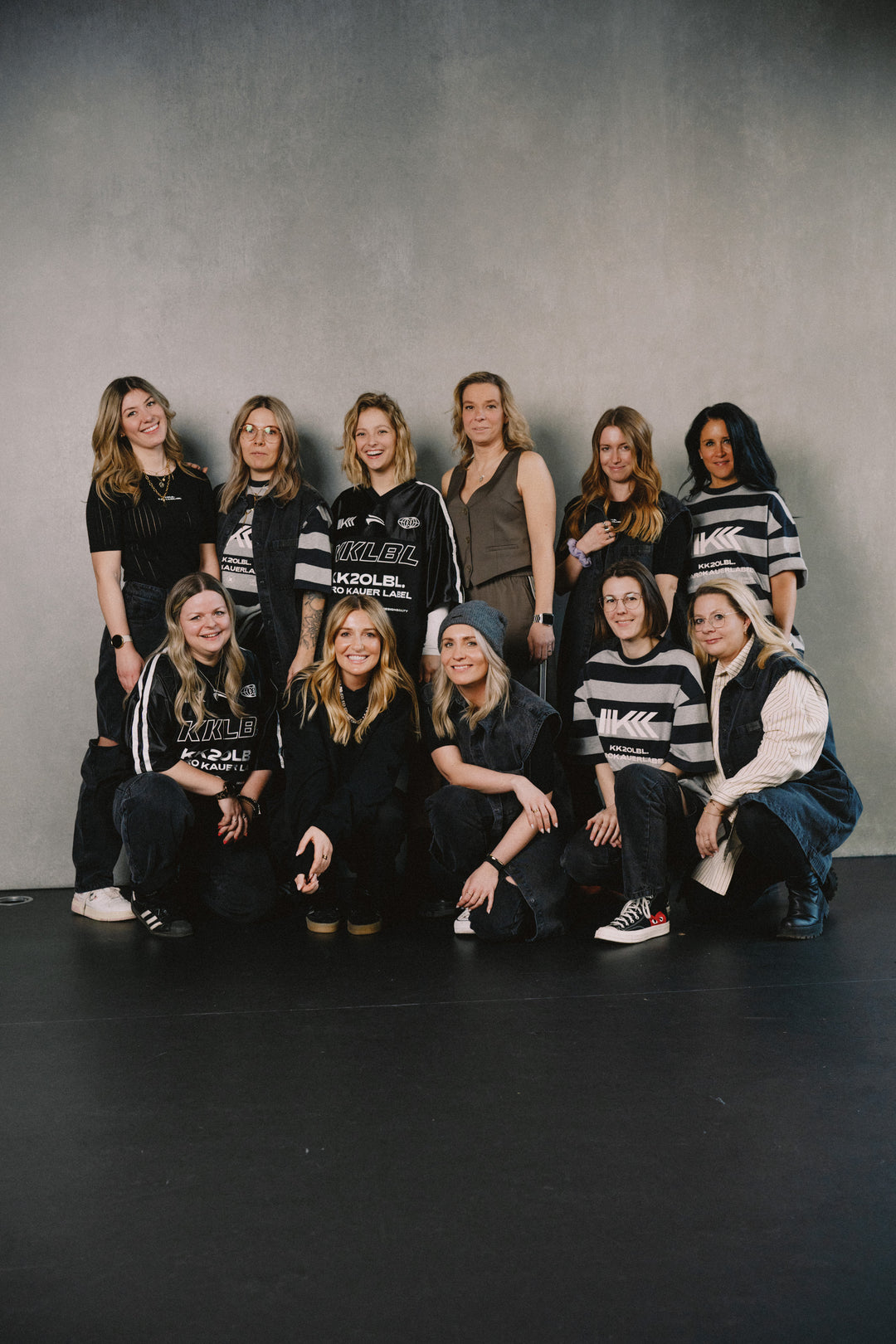 Gruppenaufnahme: Frauen in schwarzen KKLBL Jersey T-Shirts, gemeinsame Pose aus UNFILTERED
