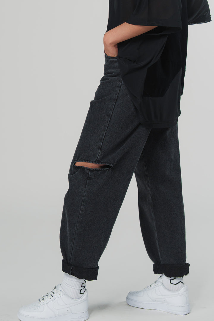 Seitliche Ansicht: Schwarze Cut-Out Jeans mit Knie-Details aus der WELCOME BLAKK Collection