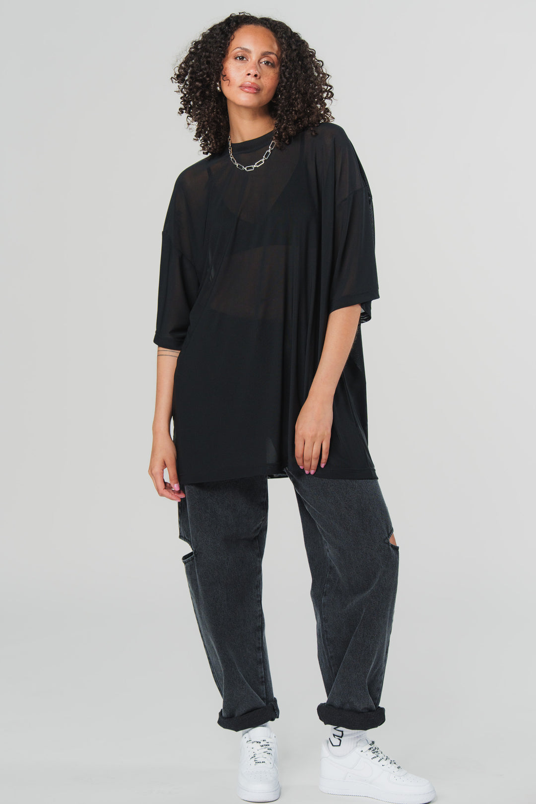Ganzkörperaufnahme: Schwarze Cut-Out Jeans mit Knie-Details, Frontalansicht aus der WELCOME BLAKK Collection