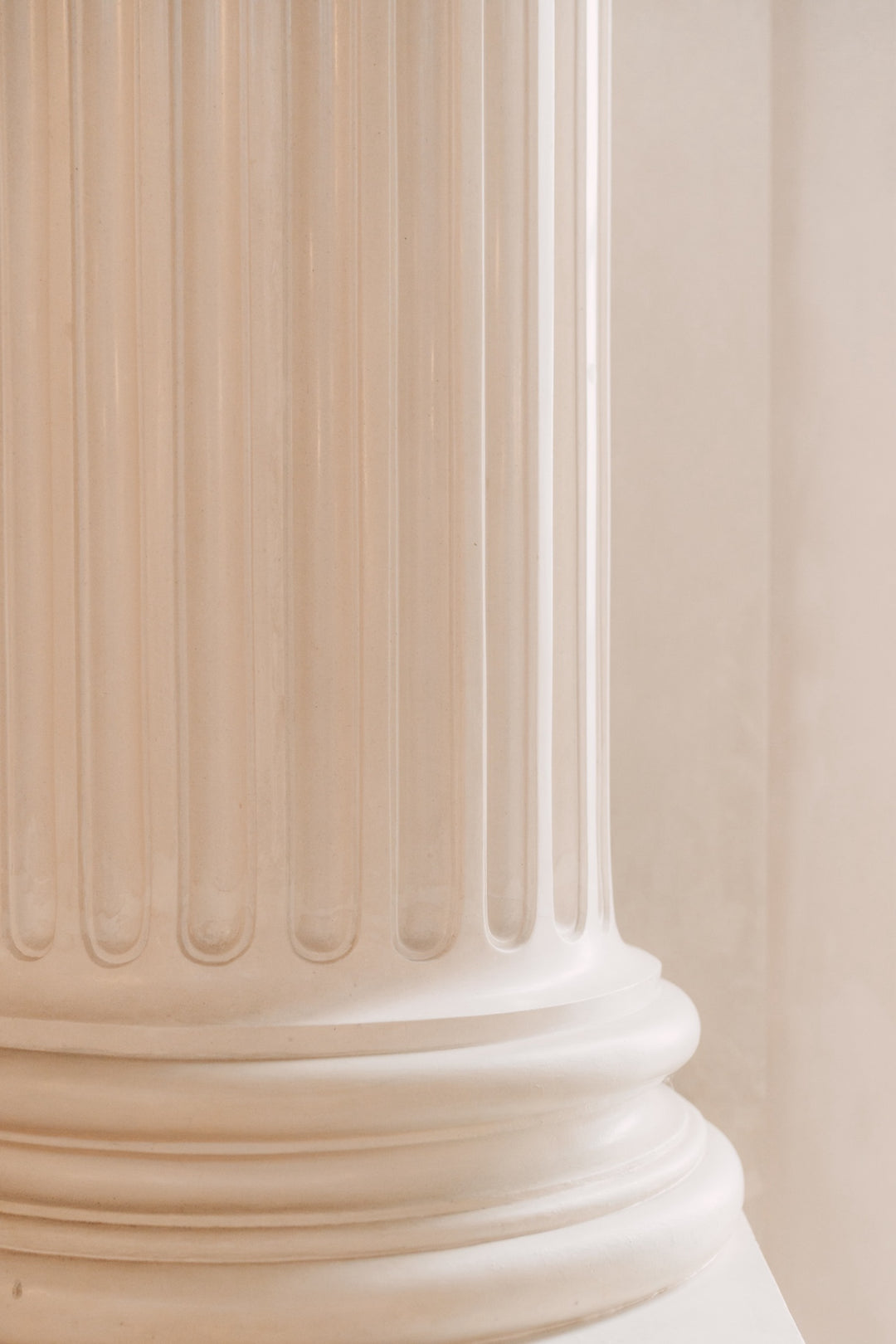 Architekturdetail: Weiße klassische Säule mit kannelierter Oberfläche und Kapitell