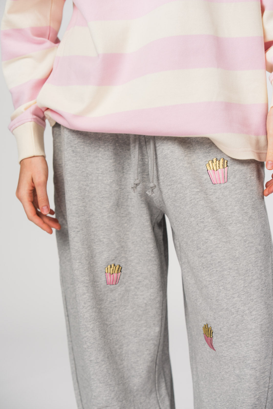 Barrel Jogger Pants Fries, Halbkörper nah, graue Baggy-Hose, Pommes-Stickerei, weiter entspannter Beinschnitt