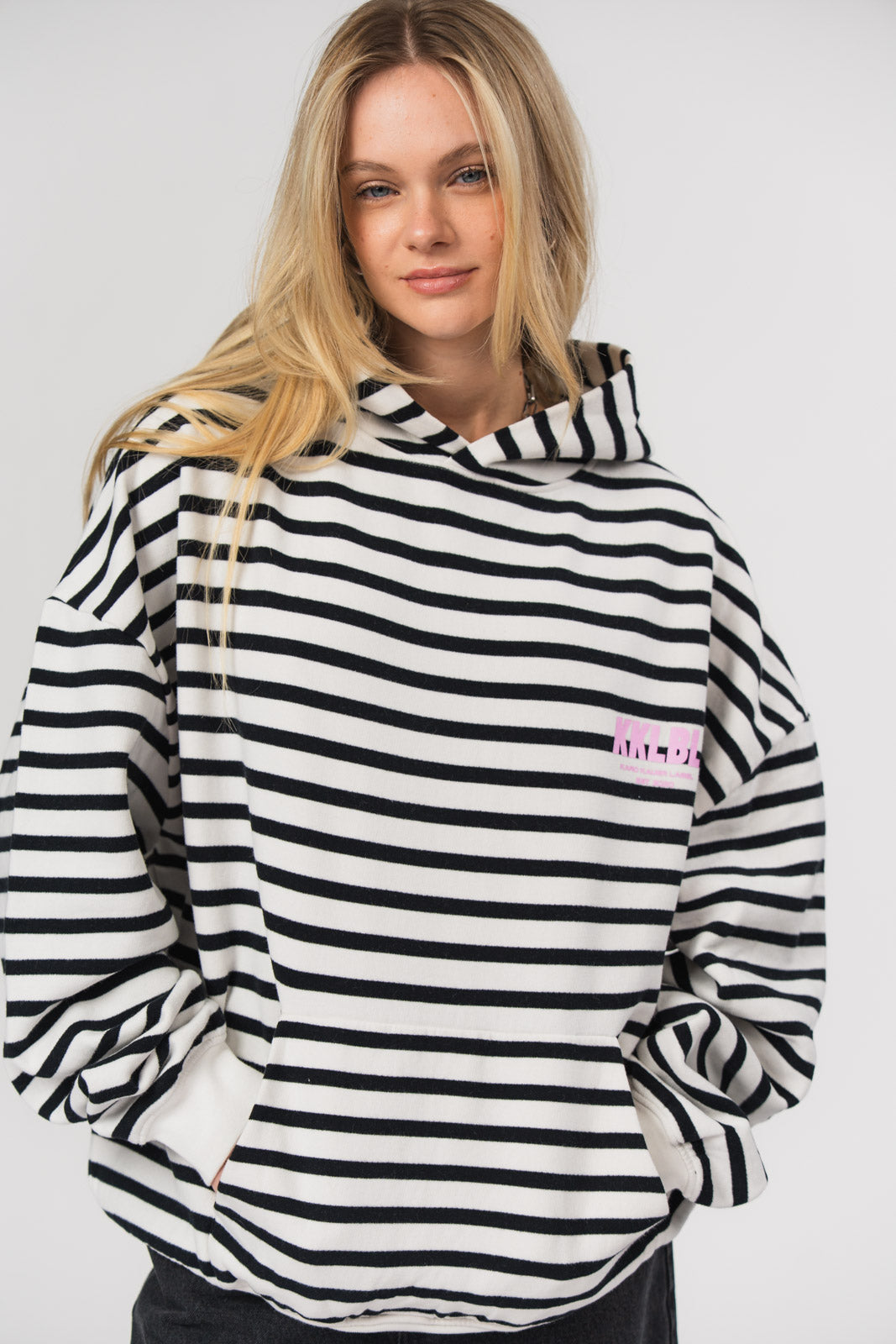 Hoodie Striped, Halbkörper frontal nah, schwarz-weiß gestreift, pinke Akzente, überschnittene Schultern