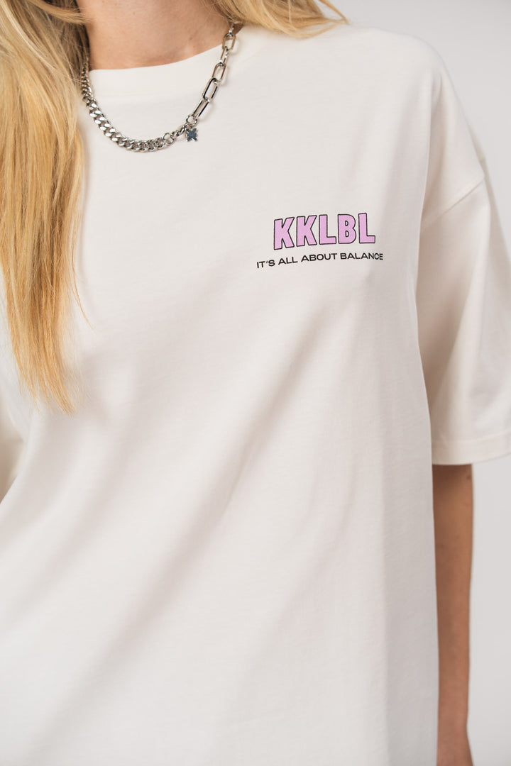 T-Shirt Fries, Detailaufnahme kleiner Print vorne und eingesticktes Logo am Ärmel, weißes Oversized-Shirt