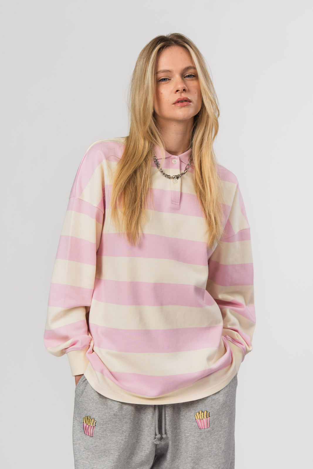 Poloshirt Striped Pink, Halbkörper frontal nah, rosa-offwhite Streifenpoloshirt, Oversized Fit, Stickerei