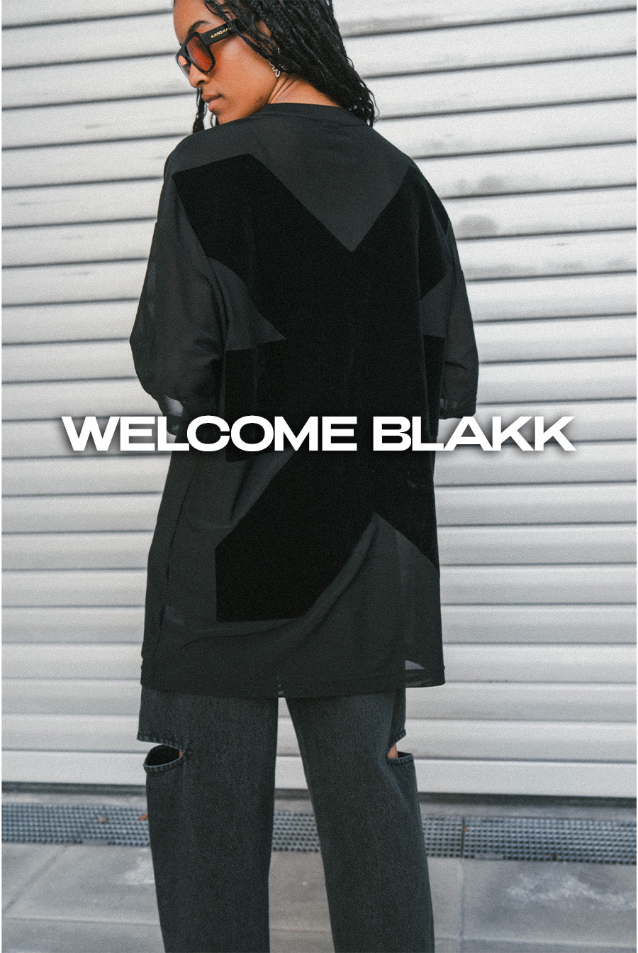 Rückenansicht einer Frau im schwarzen Mesh Shirt aus der Welcome Blakk Collection